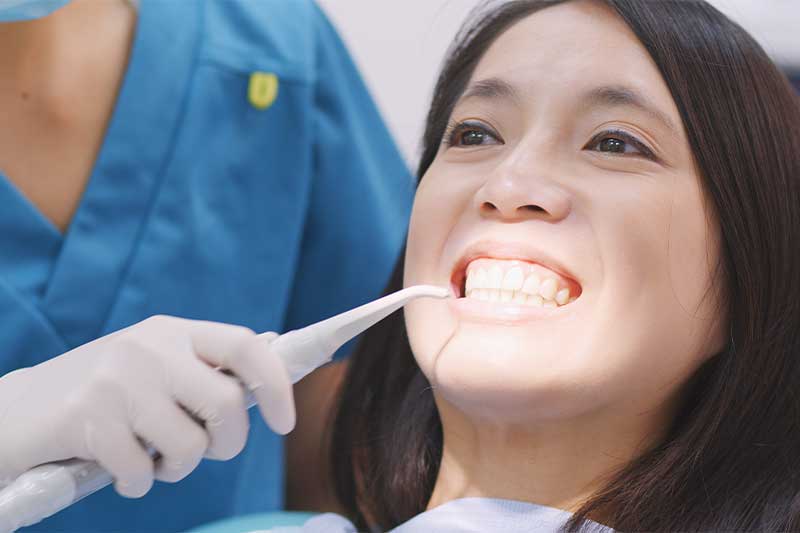 Dentist cleaning her patient's teeth