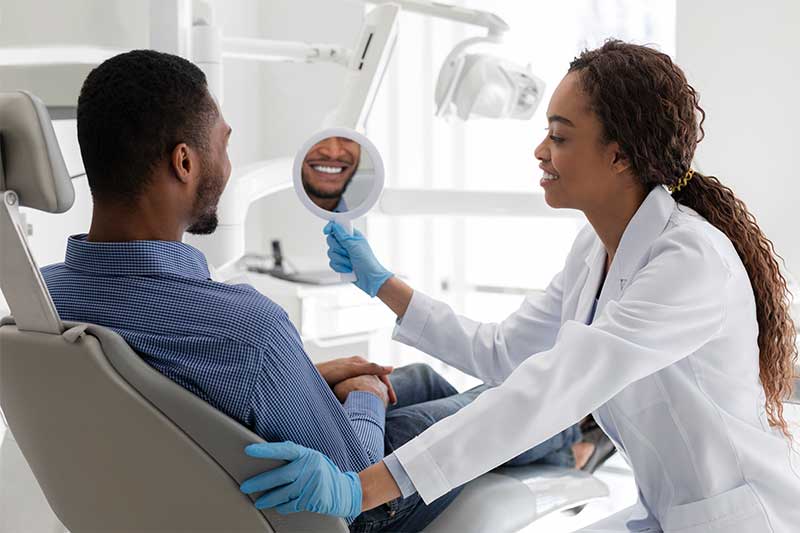 Dental patient looking at his teeth after treatments